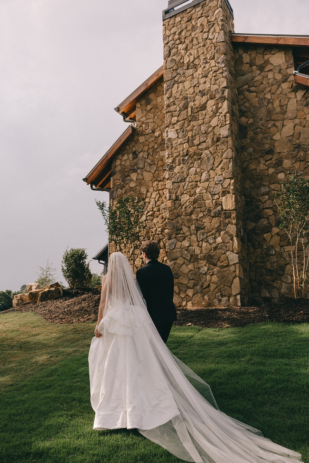 Bride and groom walking along the stone wall