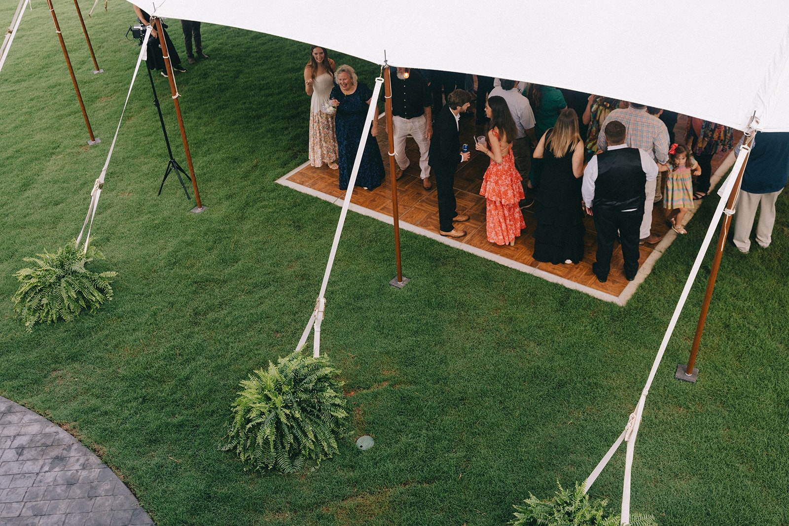 Guests dancing under the tent on the lawn