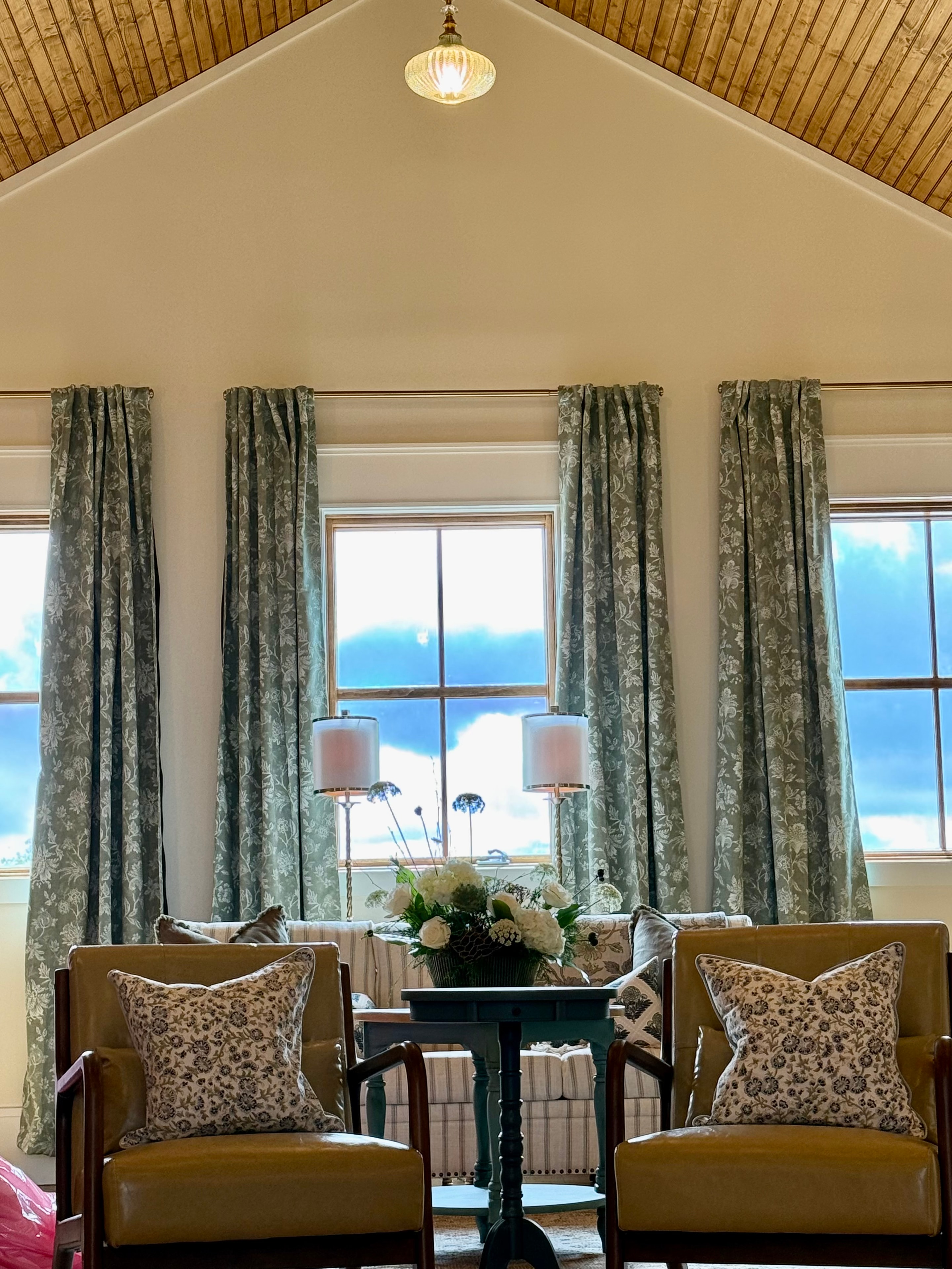 Wide view of bridal suite windows with floral drapes and pendant light